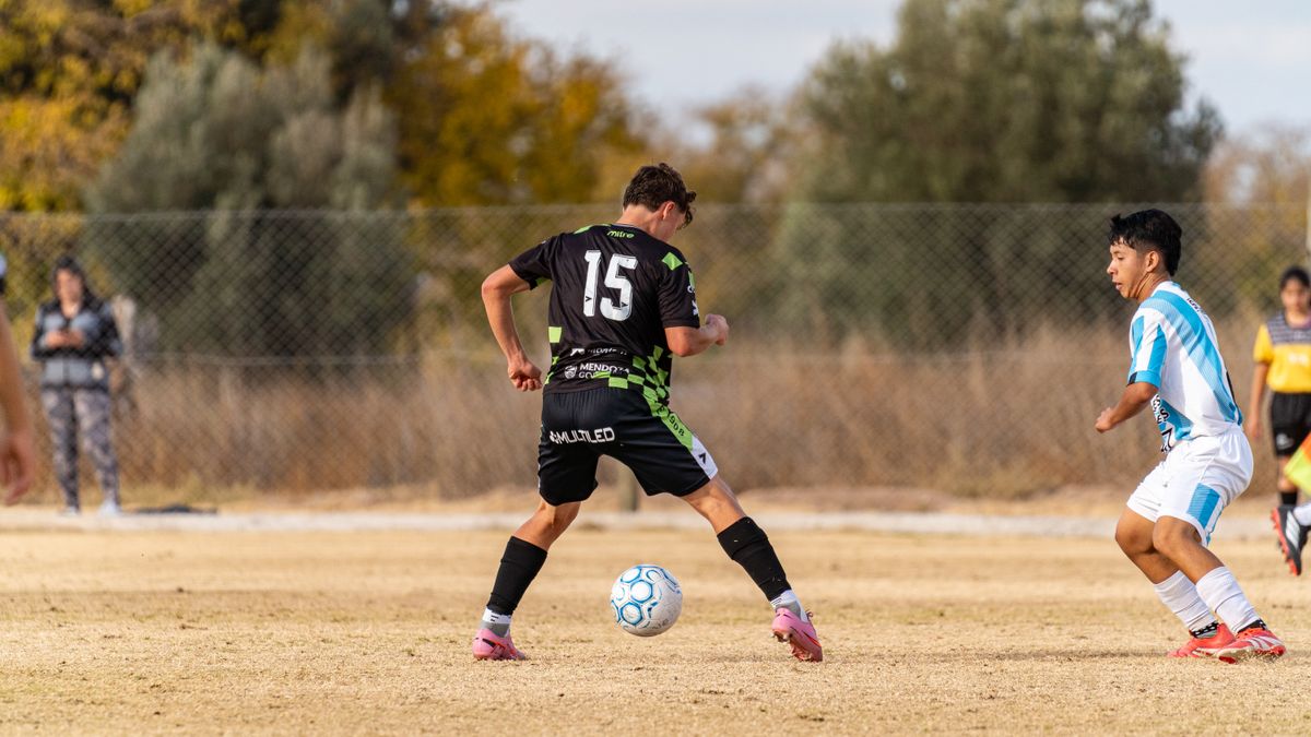 Two young soccer players in action on a sunny outdoor field during a casual game. Two young soccer players in action on a sunny outdoor field during a casual game.