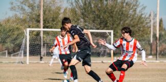 Young soccer players in action on a bright day under clear skies on an outdoor field.