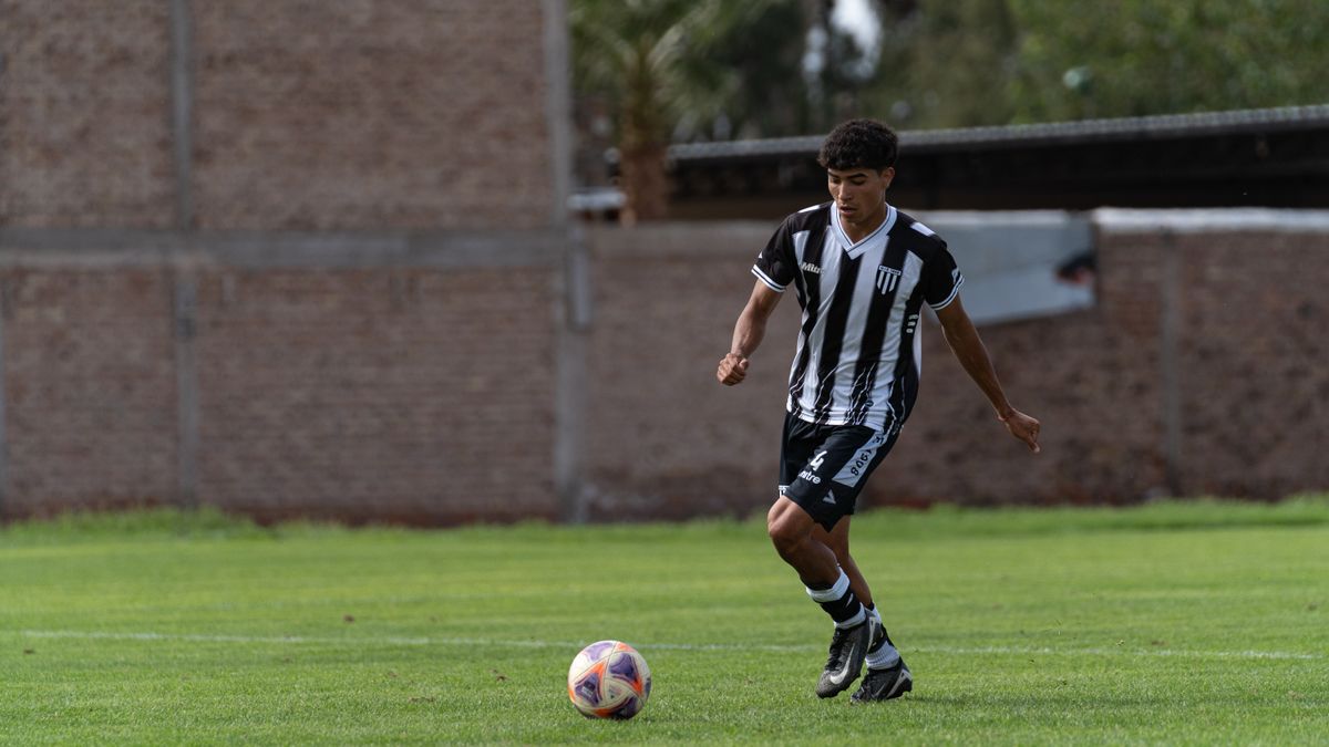 Young male soccer player dribbling on an outdoor field. Young male soccer player dribbling on an outdoor field.