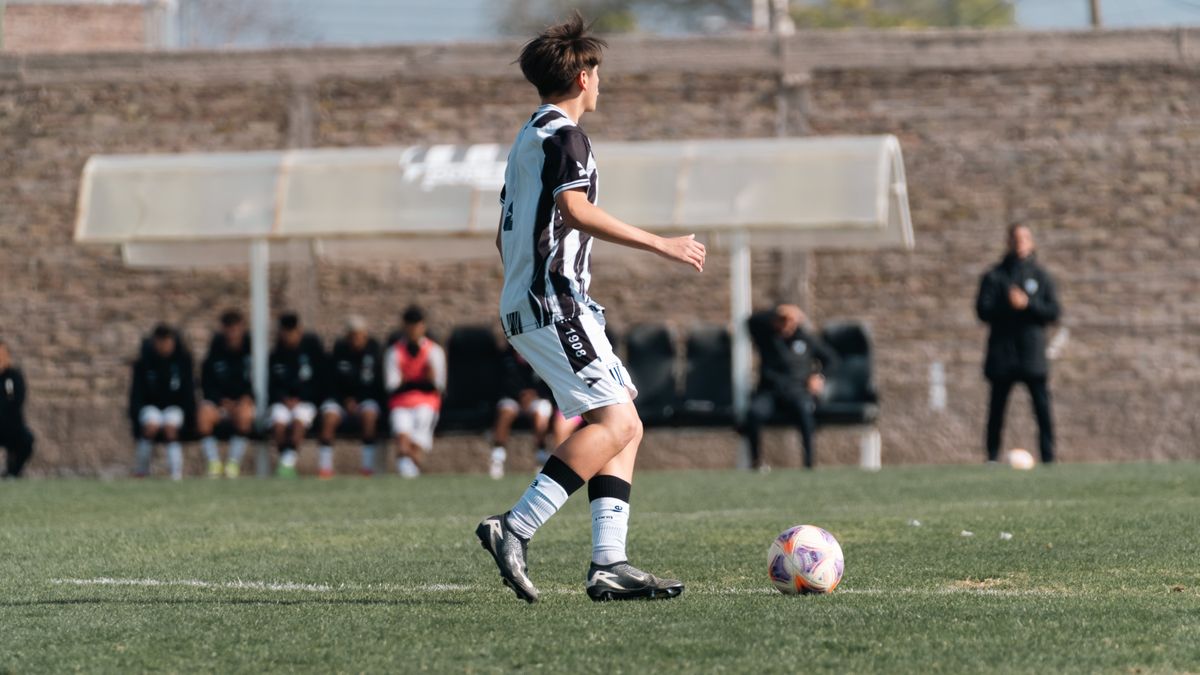 A young soccer player in action on a green field during a match. A young soccer player in action on a green field during a match.