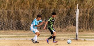 Action-packed soccer game between two teenage players on outdoor field.