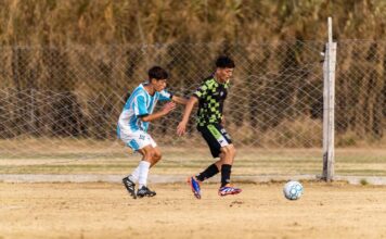 Action-packed soccer game between two teenage players on outdoor field.