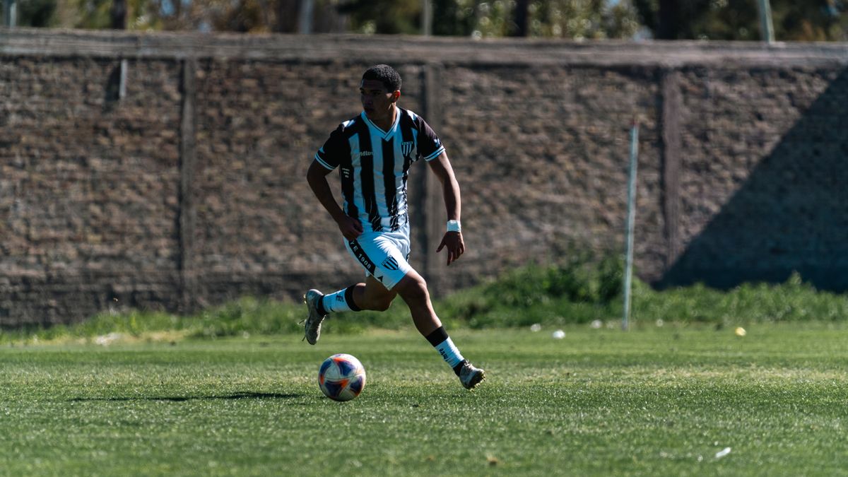 Action shot of a soccer player skillfully dribbling during a daytime match on a grassy field. Action shot of a soccer player skillfully dribbling during a daytime match on a grassy field.