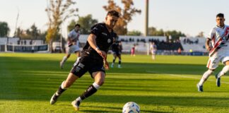 Dynamic action shot of a football match, capturing players in motion during a sunset game.