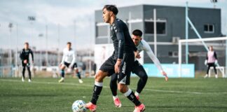 Dynamic photo capturing intense action during a soccer match with players focused on the game.