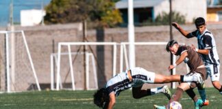 Soccer players in action during a competitive match on a sunny day.
