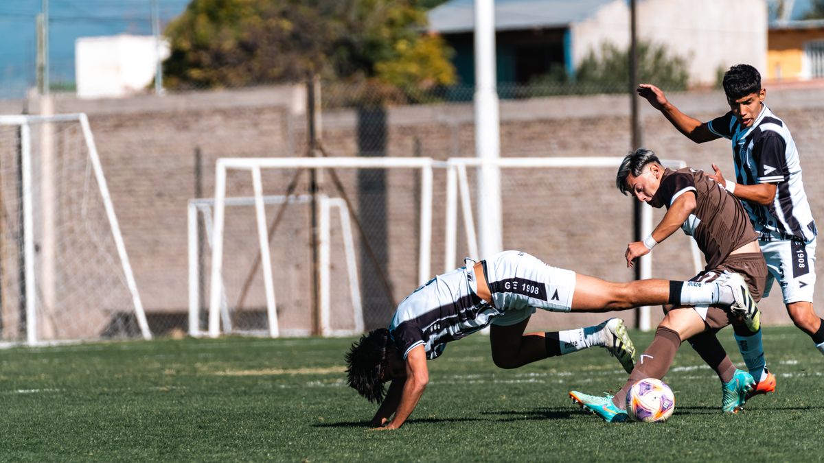 Soccer players in action during a competitive match on a sunny day. Soccer players in action during a competitive match on a sunny day.