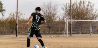 Teen soccer player wearing number 13 practicing on an outdoor field.