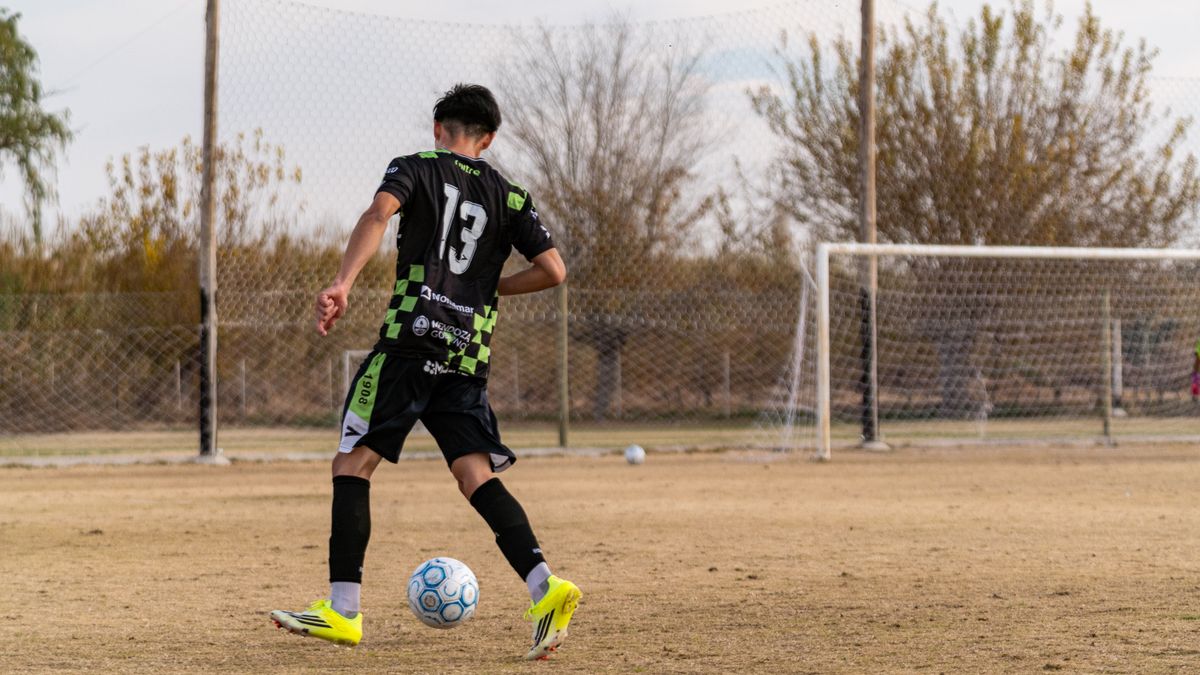 Teen soccer player wearing number 13 practicing on an outdoor field. Teen soccer player wearing number 13 practicing on an outdoor field.