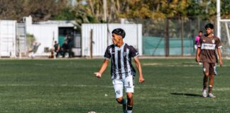 Young male soccer players competing on a sunny outdoor field.