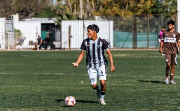 Young male soccer players competing on a sunny outdoor field.