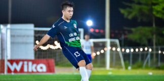 Soccer player in action on a lit field, capturing the dynamic energy of the game at night in Hà Nội.