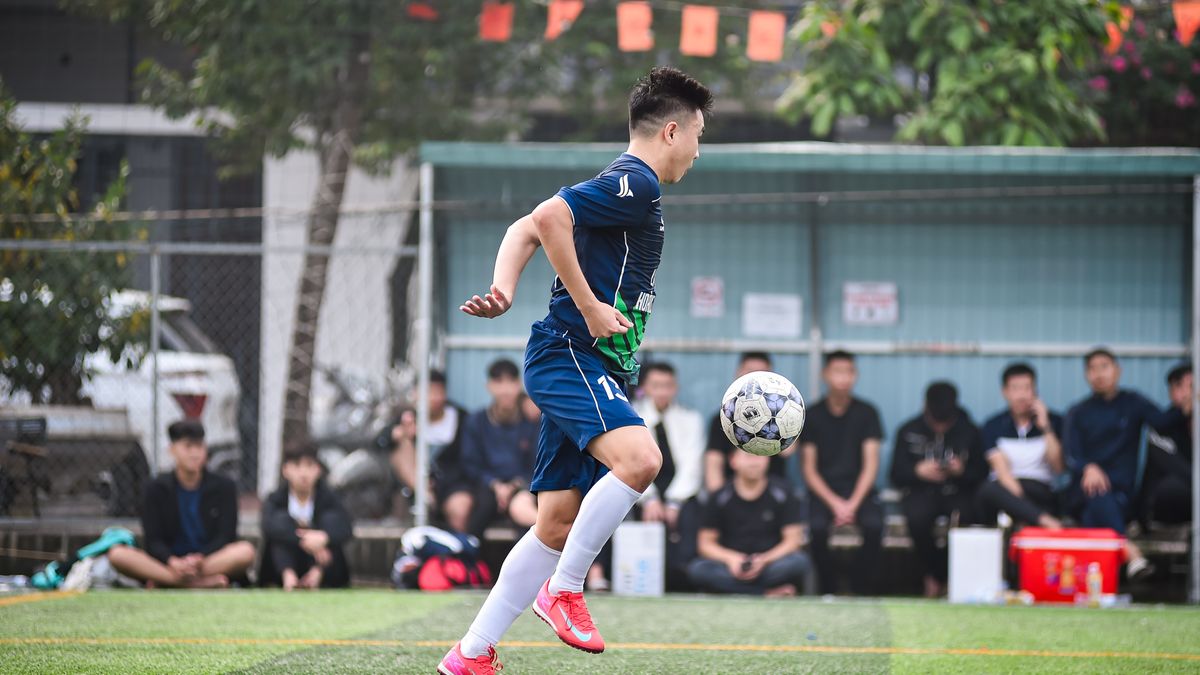 Soccer player in mid-air during a match on a Vietnam field. Soccer player in mid-air during a match on a Vietnam field.