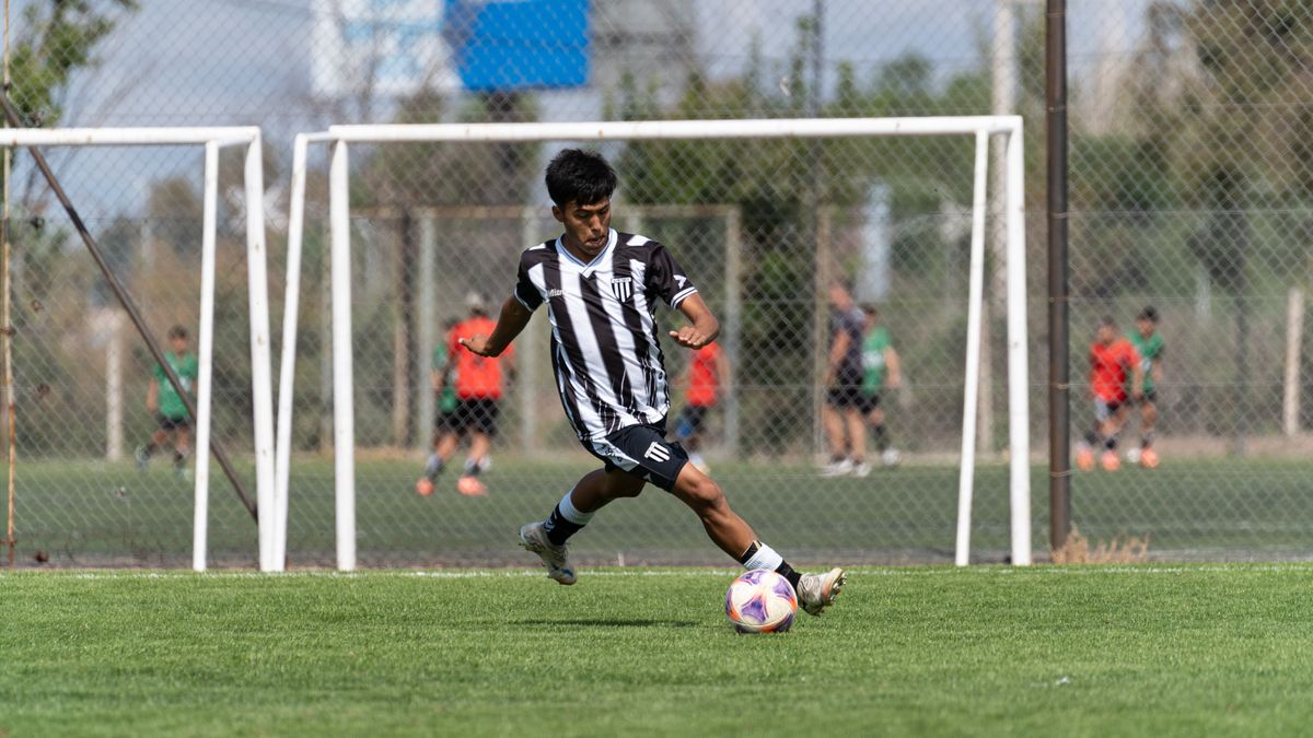 Teen soccer player kicking a ball during a daytime match, showcasing athletic skills on the field. Teen soccer player kicking a ball during a daytime match, showcasing athletic skills on the field.