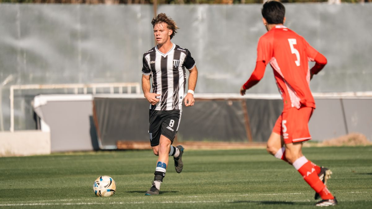 Two soccer players in action during a competitive match on a sunny day. Two soccer players in action during a competitive match on a sunny day.
