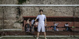A young soccer player standing in front of a goal with a ball in Istanbul, Turkey.