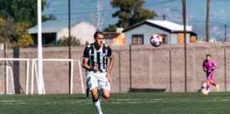Dynamic shot of a soccer player running on a field during a match.