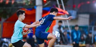 Dynamic football players in action during a game in Hà Nội, showcasing athleticism and teamwork.