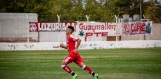 Dynamic shot of a young soccer player running on a football field during a match.