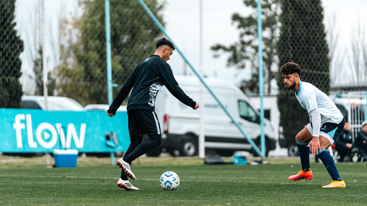 Two players in action during a competitive outdoor soccer match on a grassy field. Two players in action during a competitive outdoor soccer match on a grassy field.