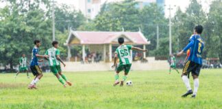 A dynamic soccer match played in the rain, capturing young players in action on a grassy field.