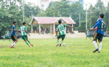 A dynamic soccer match played in the rain, capturing young players in action on a grassy field.