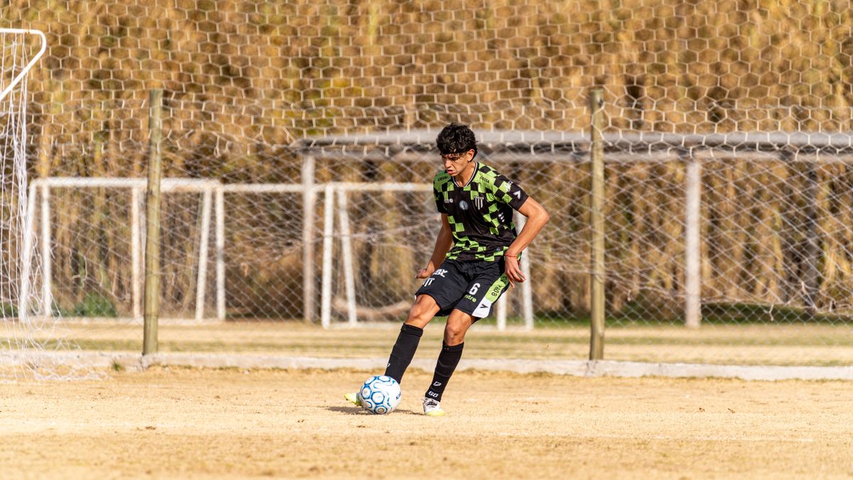 A teenager in a green camo jersey focusing on the soccer ball during practice outdoors. A teenager in a green camo jersey focusing on the soccer ball during practice outdoors.