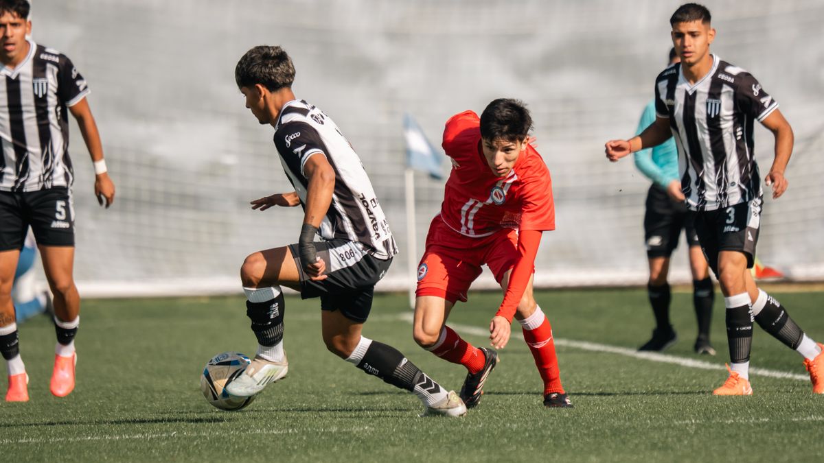 Youth soccer players in dynamic action during a competitive match on a bright day. Youth soccer players in dynamic action during a competitive match on a bright day.