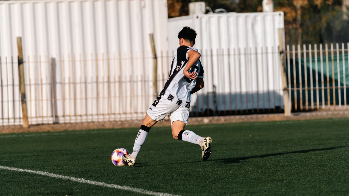 Back view of a young soccer player in motion during a game on a sunny day. Back view of a young soccer player in motion during a game on a sunny day.