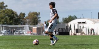 Dynamic action shot of a soccer player mid-game on a sunny day.
