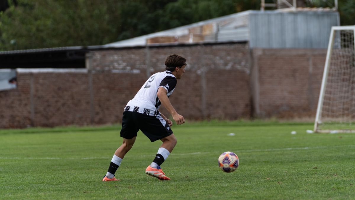 A male soccer player in action on a grassy field during a day match. A male soccer player in action on a grassy field during a day match.