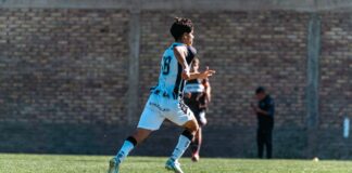 Dynamic shot of a young soccer player in mid-action during a game outdoors.