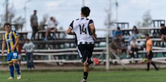 Soccer player in action during an outdoor amateur match with spectators.