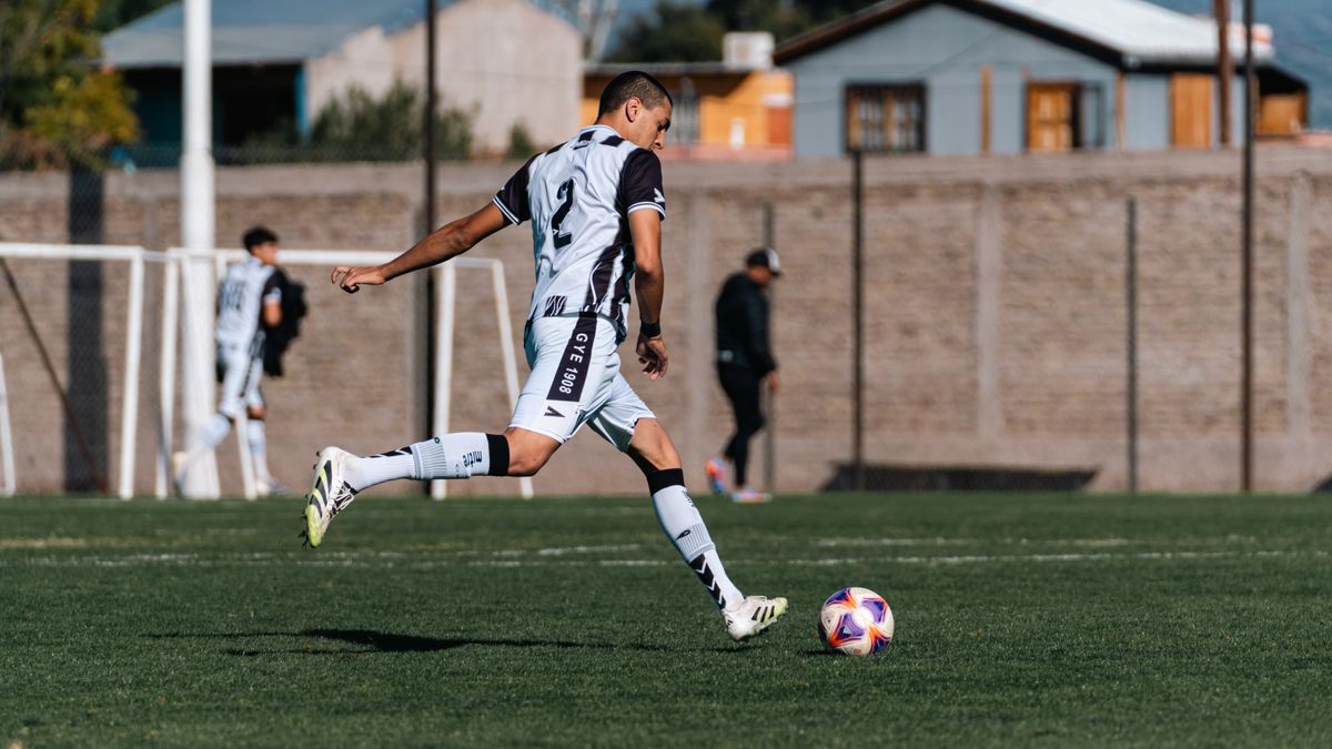 Dynamic shot of a young soccer player kicking a ball during a match on a sunny day. Dynamic shot of a young soccer player kicking a ball during a match on a sunny day.