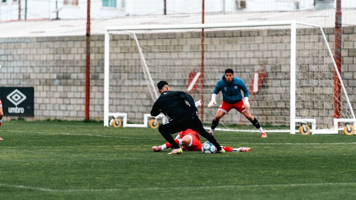 Action-packed football scene with players and a goalkeeper on green field. Action-packed football scene with players and a goalkeeper on green field.