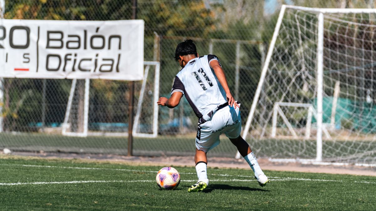 Action shot of a soccer player dribbling on a sunny outdoor field, showcasing athletic movement. Action shot of a soccer player dribbling on a sunny outdoor field, showcasing athletic movement.