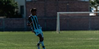 Young male soccer player mid-action on an outdoor field during a match.