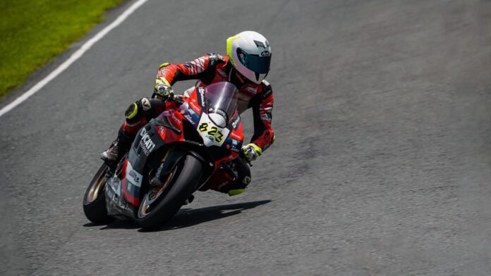 Motorcycle racer leaning into a curve on Batangas racetrack during an intense competition.