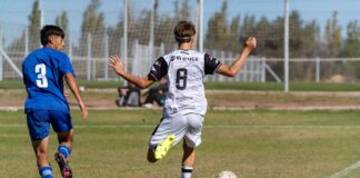 Two young soccer players in action on a sunny outdoor field.