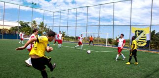 Dynamic soccer match with players in action on a bright sunny day.