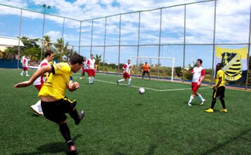 Dynamic soccer match with players in action on a bright sunny day.