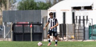 Male soccer player in black and white uniform on the field, outdoor match setting.