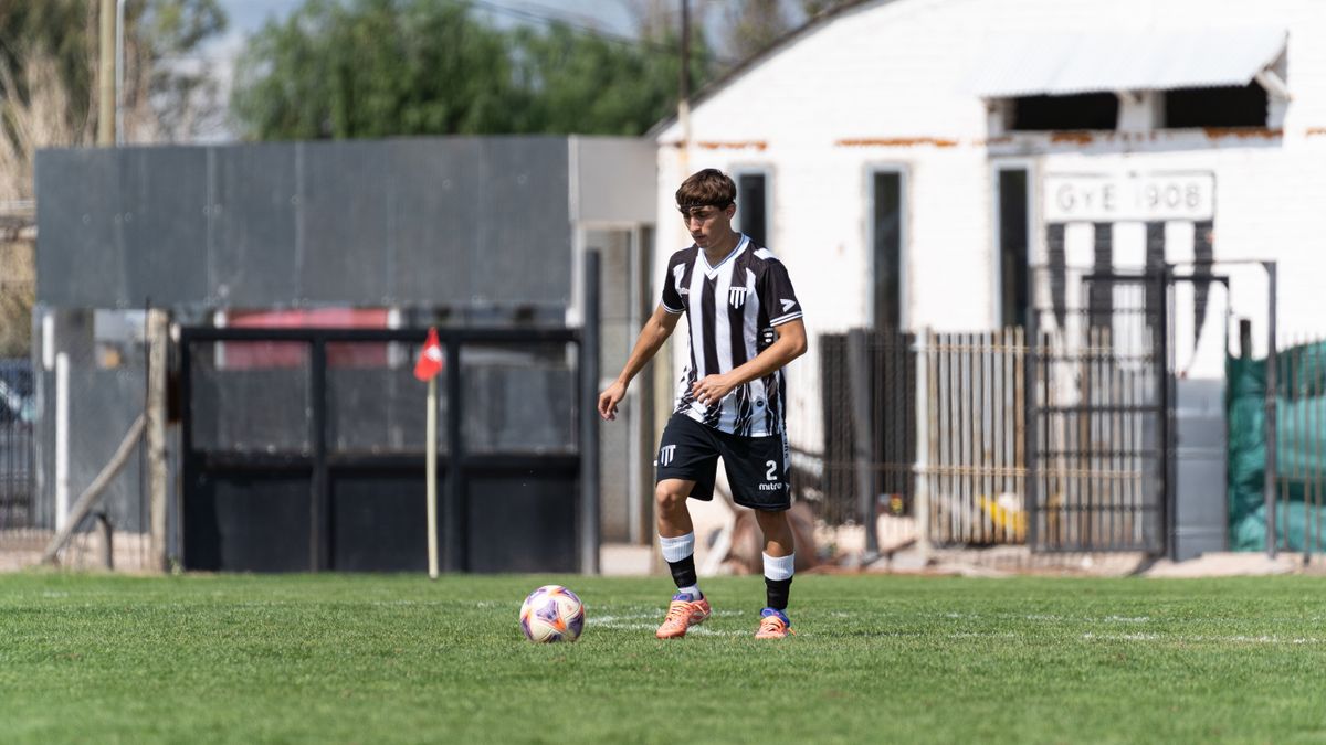 Male soccer player in black and white uniform on the field, outdoor match setting. Male soccer player in black and white uniform on the field, outdoor match setting.