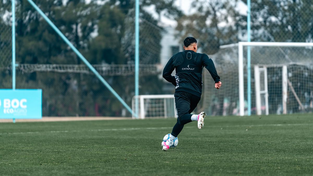Football player practices dribbling on a professional outdoor field, emphasizing athleticism and skill. Football player practices dribbling on a professional outdoor field, emphasizing athleticism and skill.