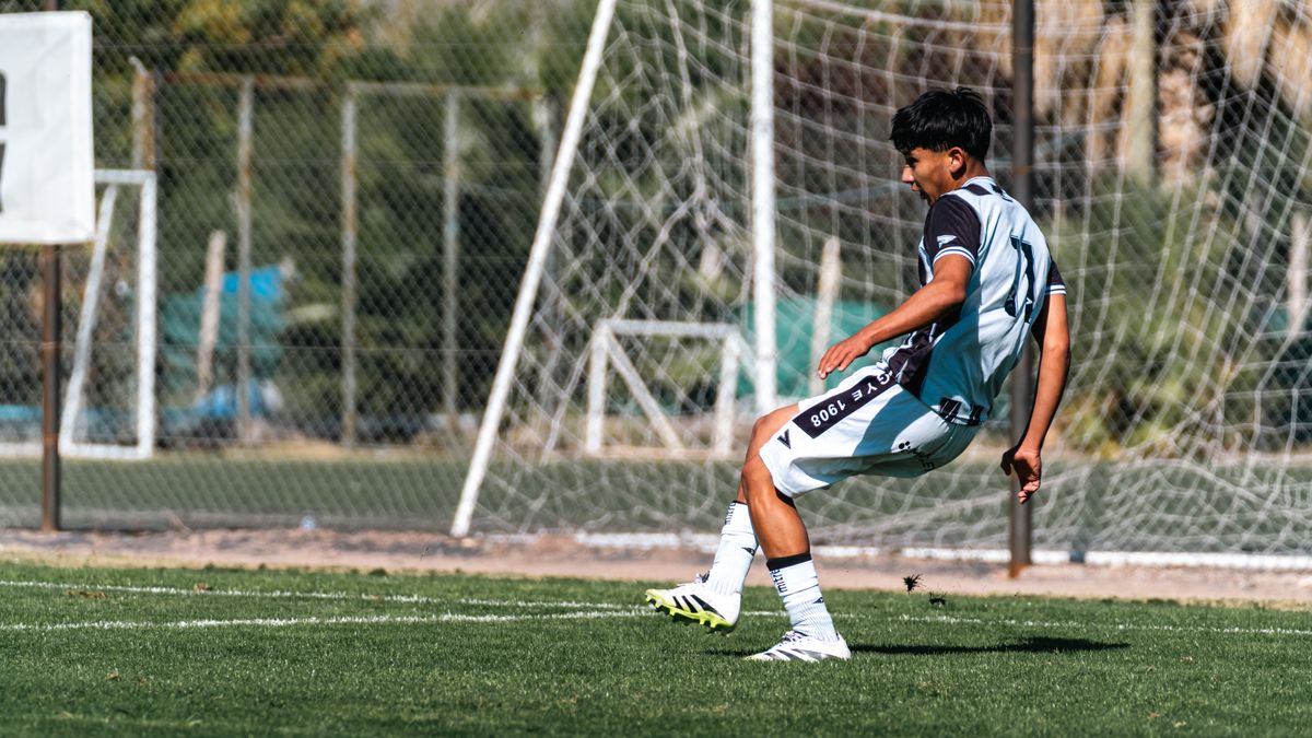 Teen football player kicks ball on sunny day outdoors, showcasing skill and athleticism in a match. Teen football player kicks ball on sunny day outdoors, showcasing skill and athleticism in a match.