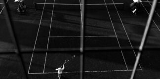 Black and white photo of a tennis match in Buenos Aires, capturing dynamic motion and shadow play.