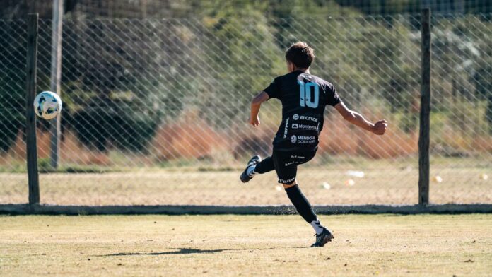 Youth soccer player in motion kicking a ball on a sunny outdoor field. Youth soccer player in motion kicking a ball on a sunny outdoor field.