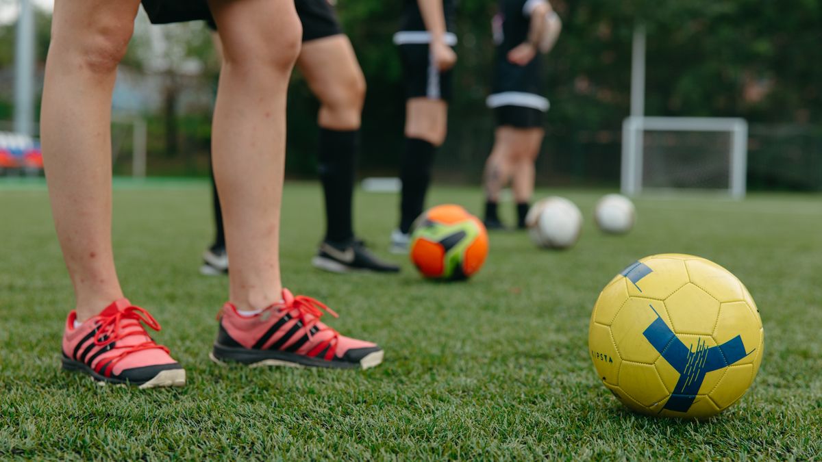 Close-up of soccer players on a grass field with colorful soccer balls, displaying teamwork and sportsmanship. Close-up of soccer players on a grass field with colorful soccer balls, displaying teamwork and sportsmanship.