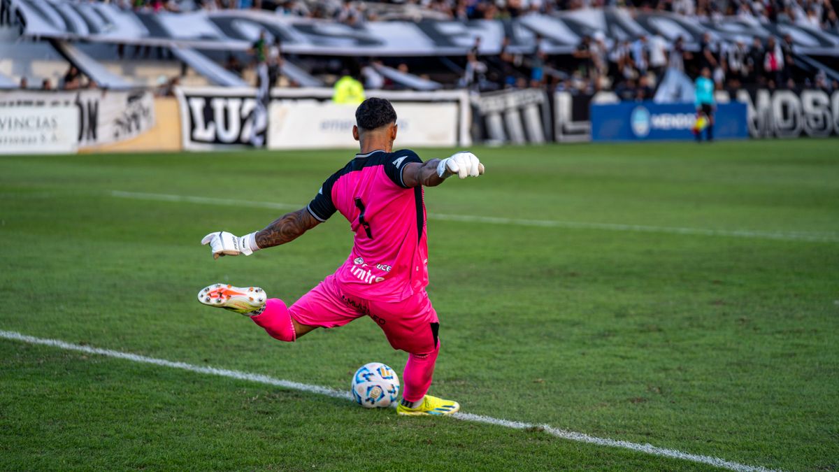 Goalkeeper in pink kit kicking the ball during a soccer match. Goalkeeper in pink kit kicking the ball during a soccer match.