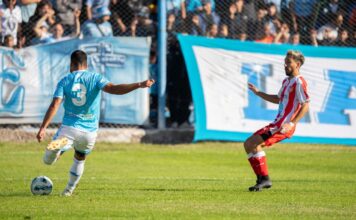 Action-packed soccer match with players in blue and red uniforms competing fiercely on the field.